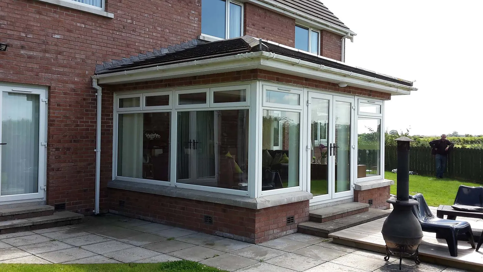 Newly built extension at the back of the house with garden furniture and a log burner