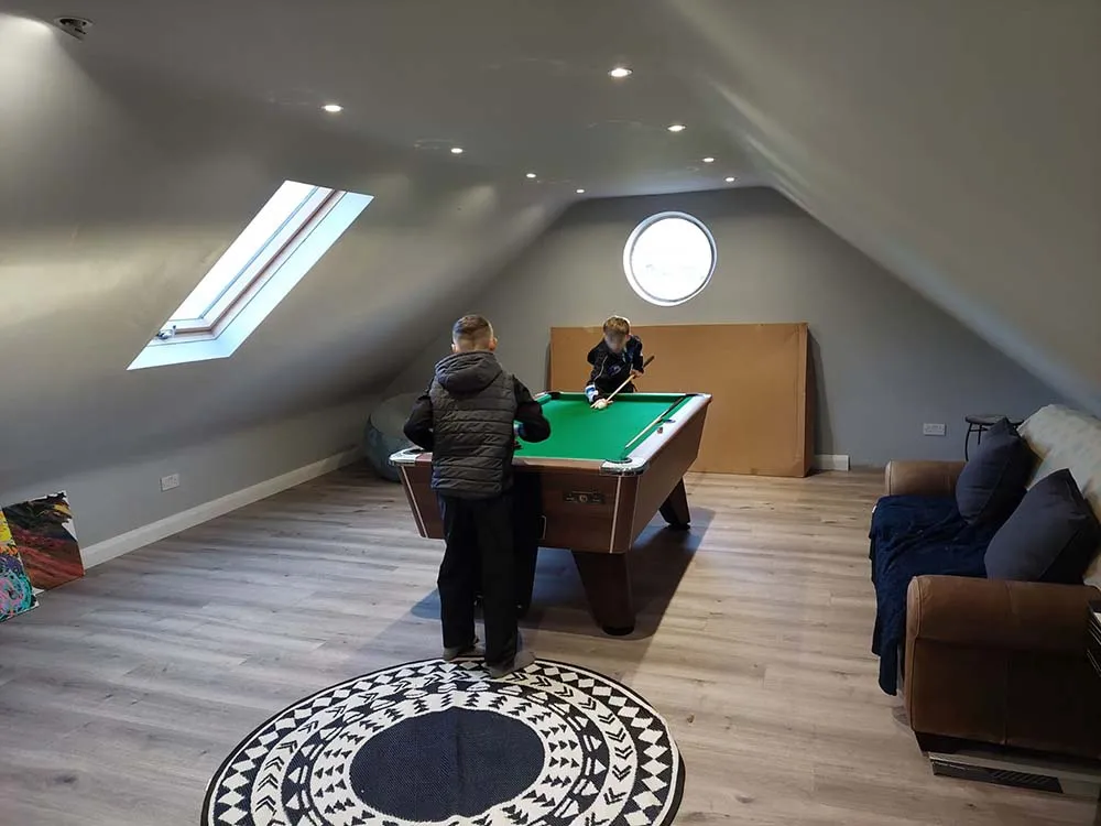 Loft conversion with two children playing pool