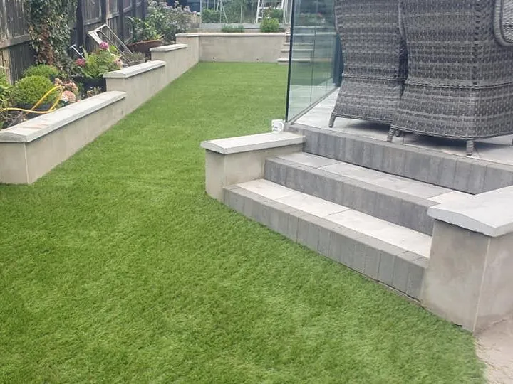 Newly paved steps leading to patio with garden furniture