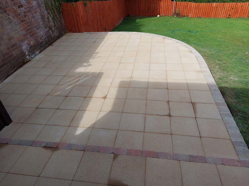 Newly laid raised, rounded patio with sandstone paving slabs